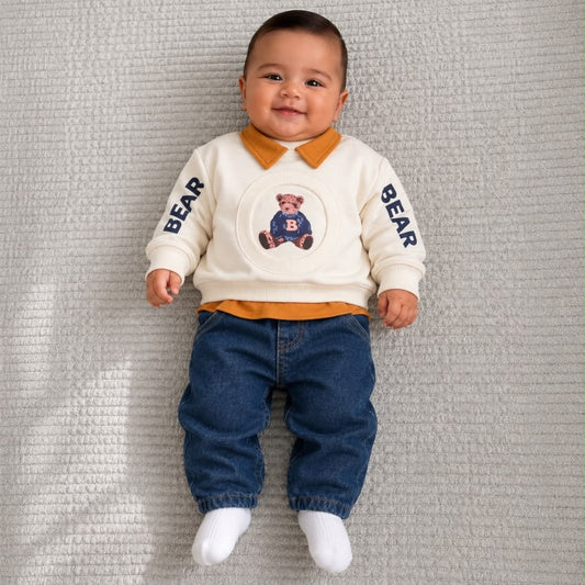 Baby wearing cream teddy bear sweatshirt with mustard collar and blue jeans
