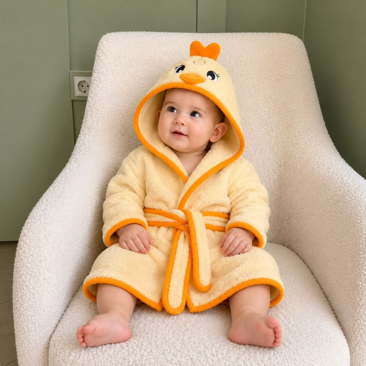 Baby wearing little chick hooded bathrobe on armchair