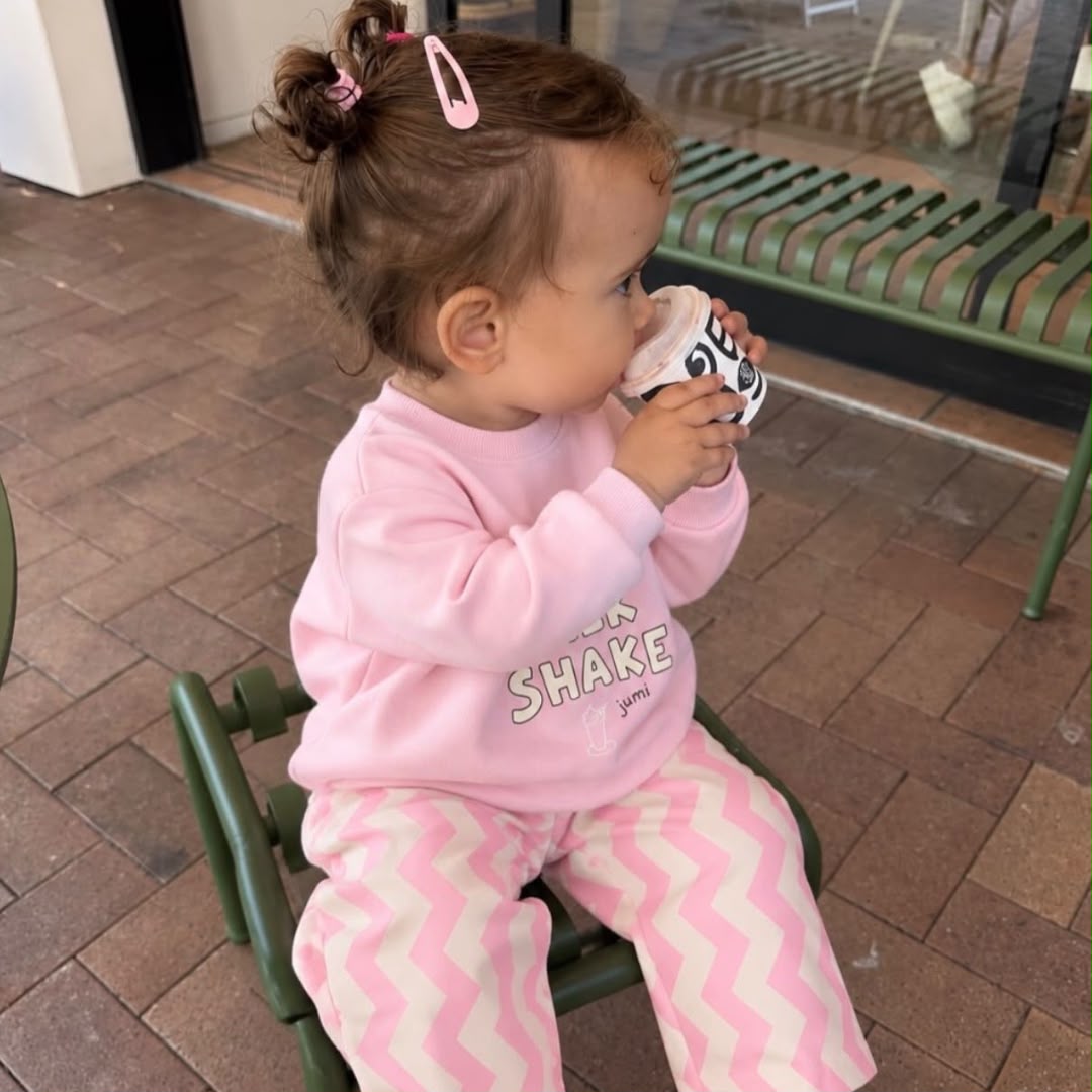 Toddler wearing pink Milk Shake sweatshirt and matching chevron trousers