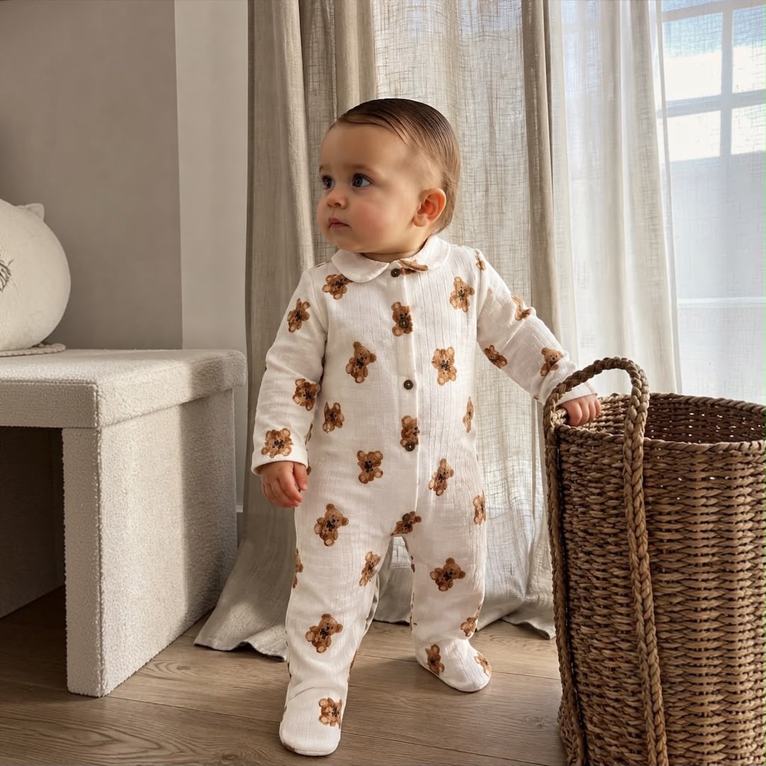 Baby boy wearing Teddy Bear Muslin Romper standing by wicker basket