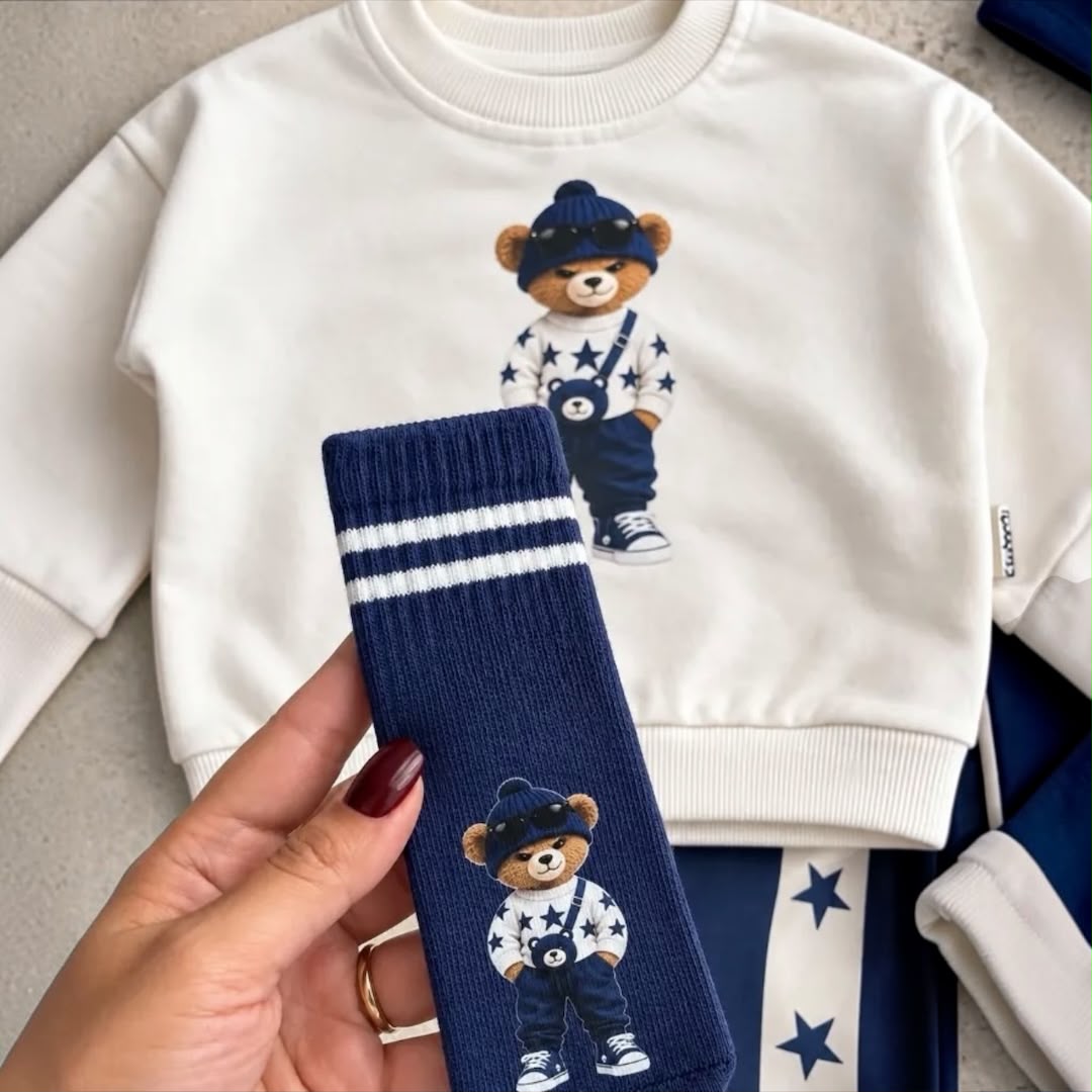 Close-up of navy baby sock with bear character and white stripes