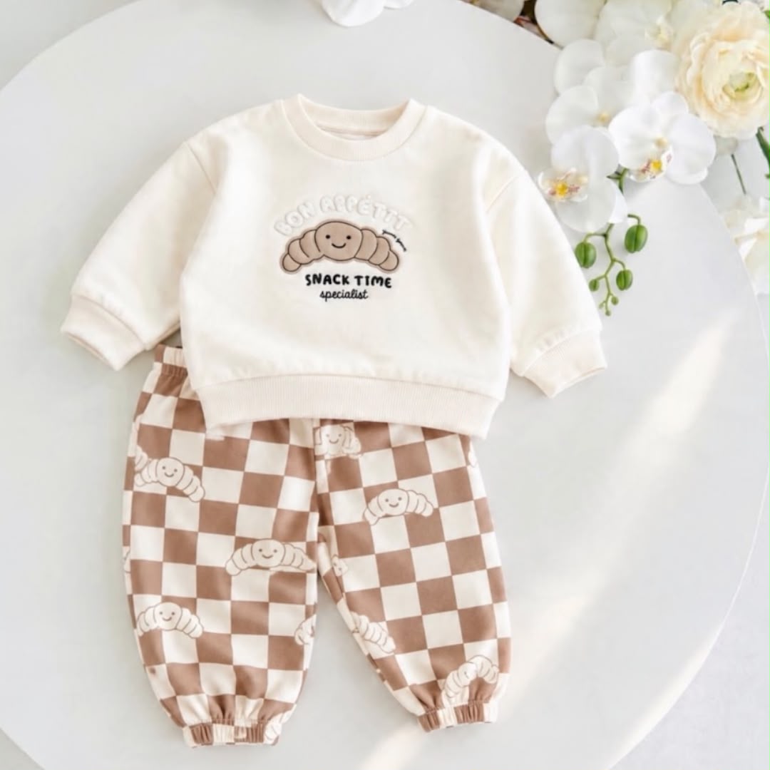Cream croissant baby sweatshirt with brown and cream checkered joggers laid flat
