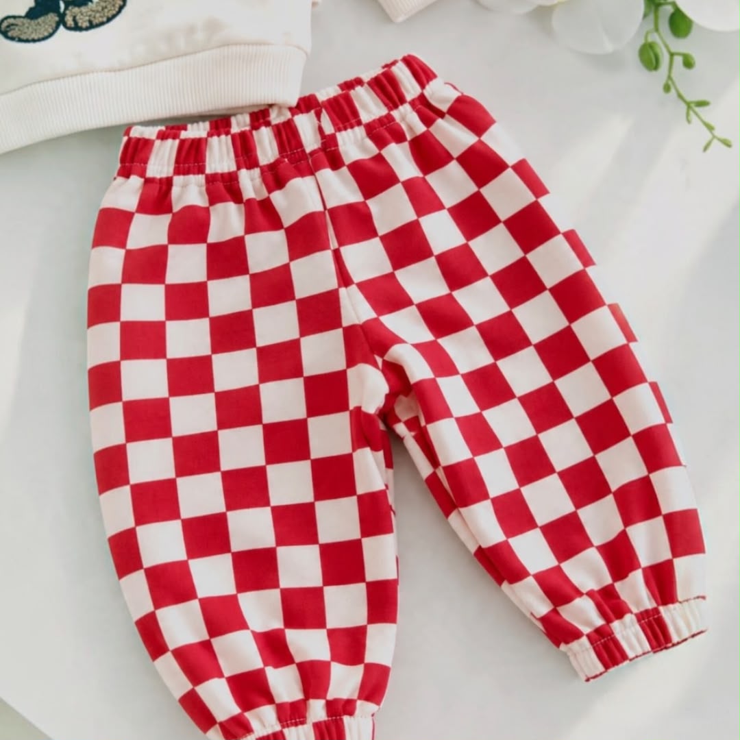 Close-up of red and cream checkered baby joggers with elasticated waistband