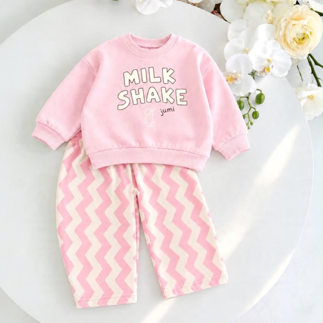 Pink Milk Shake baby sweatshirt with pink and cream chevron trousers laid flat
