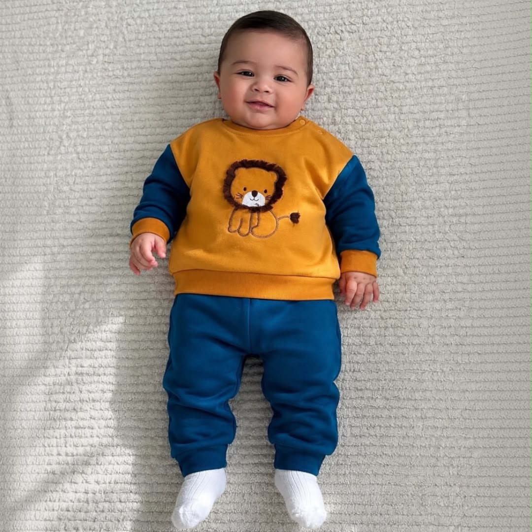 Baby wearing Lion Appliqué Sweatshirt & Jogger Set lying down smiling
