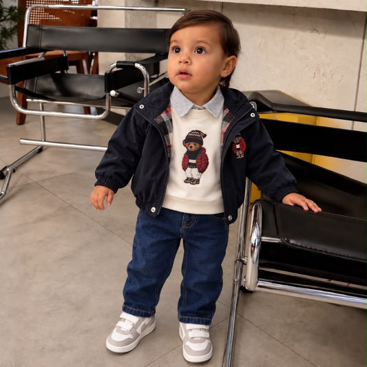 Toddler wearing navy bear jacket cream collared sweatshirt and blue jeans