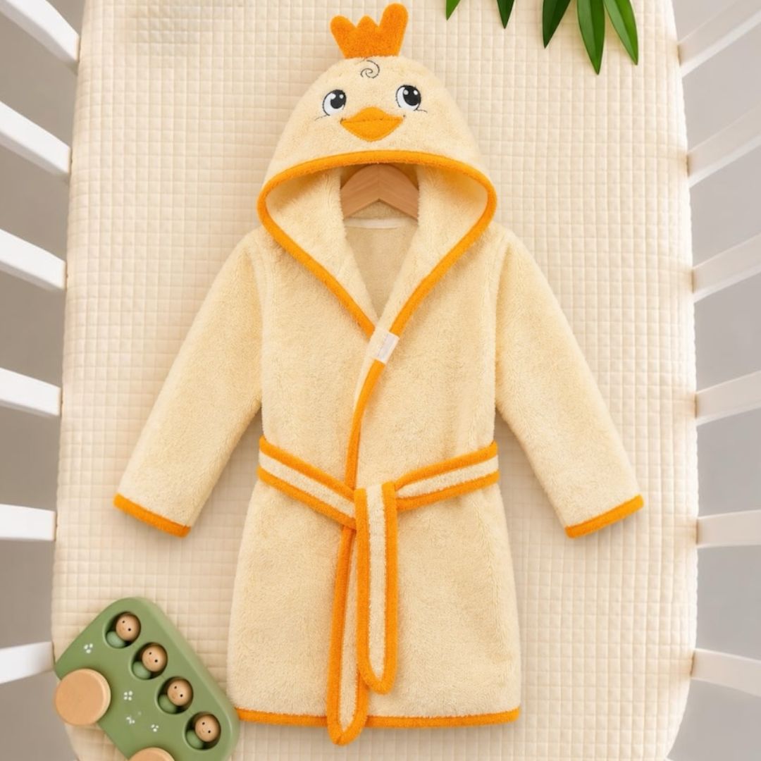 Little chick hooded baby bathrobe flat lay on crib