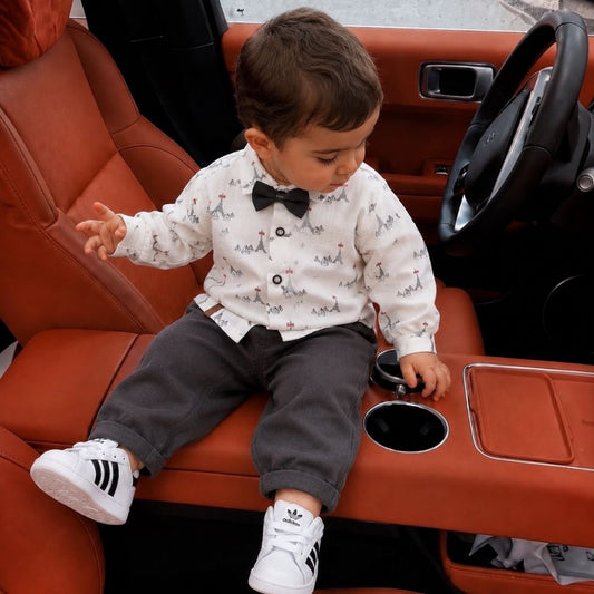 Baby boy wearing little gentleman set in luxury car