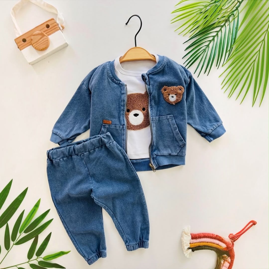 Baby 3-Piece Teddy Bear Denim Zip Jacket Tee & Jogger Set flat lay with tropical leaves