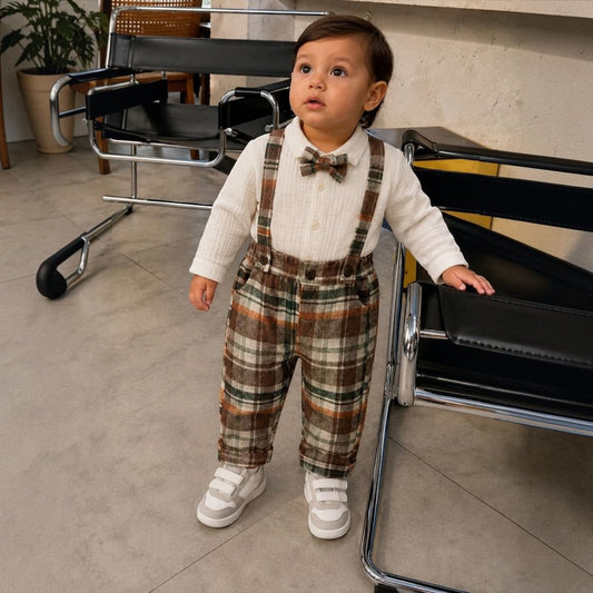 Baby boy wearing plaid suspender set with white sneakers
